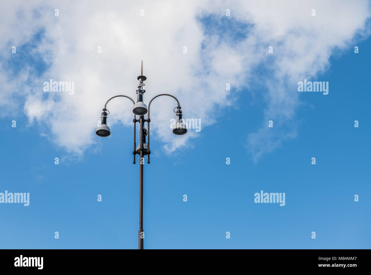 Retro european style urban light high streetlamp against blue sky and big white cloud Stock Photo