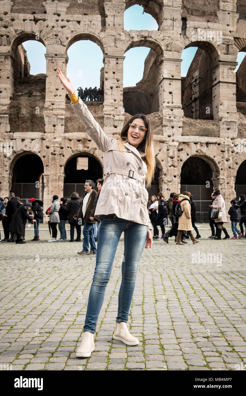 Young pretty tourist woman smiling and pointing out, colosseum monument in Rome Italy Stock Photo