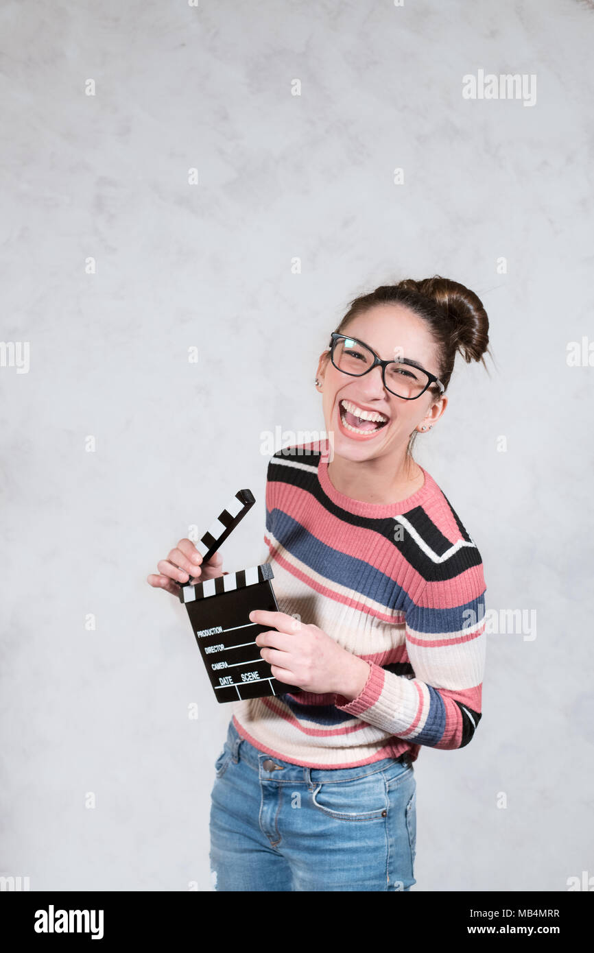 Young woman actress comedy funny grimace face expression mouth open with movie clapper board Stock Photo