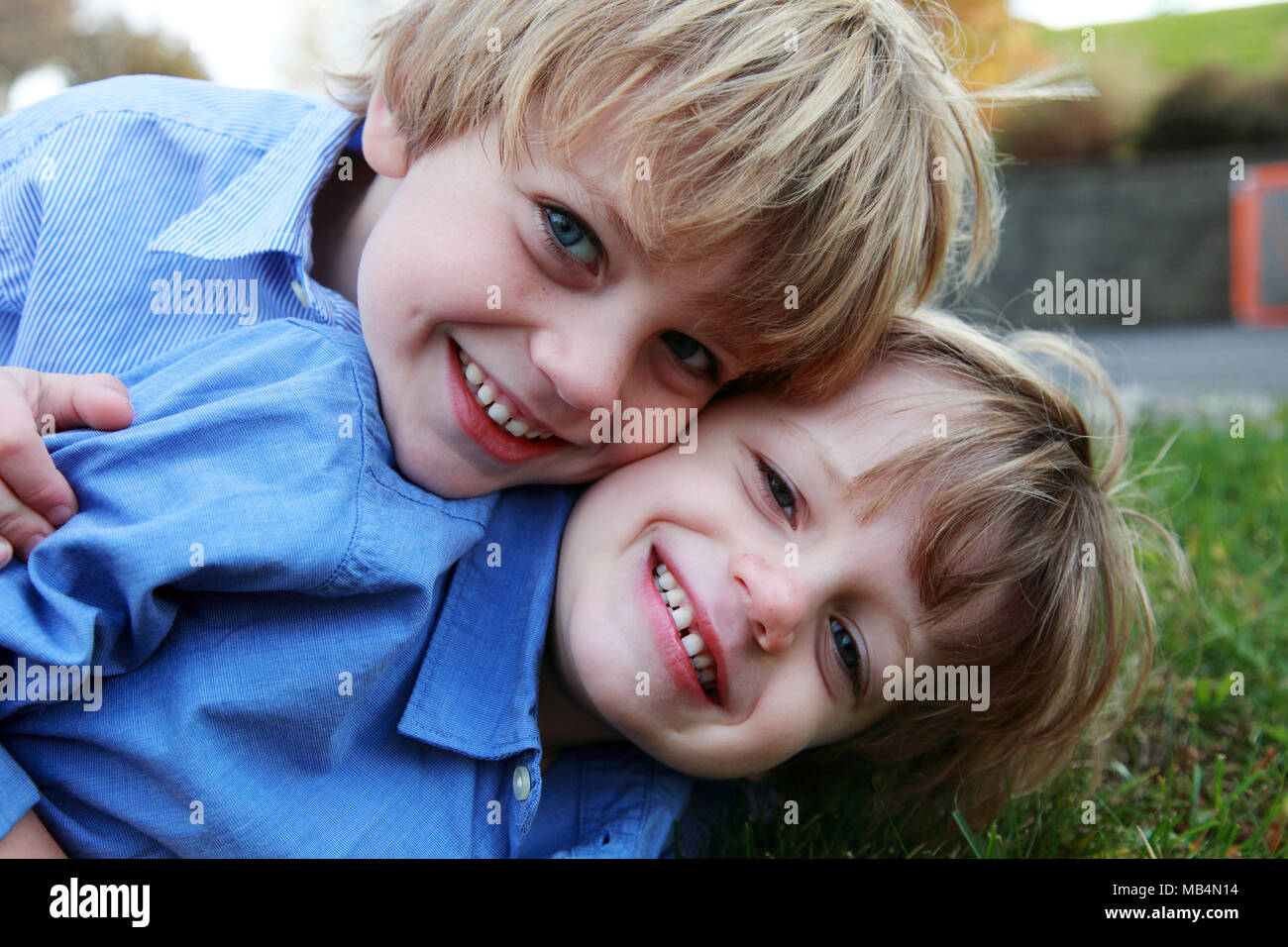 Portrait of Two Smiling Boys Laying on Grass Stock Photo - Alamy