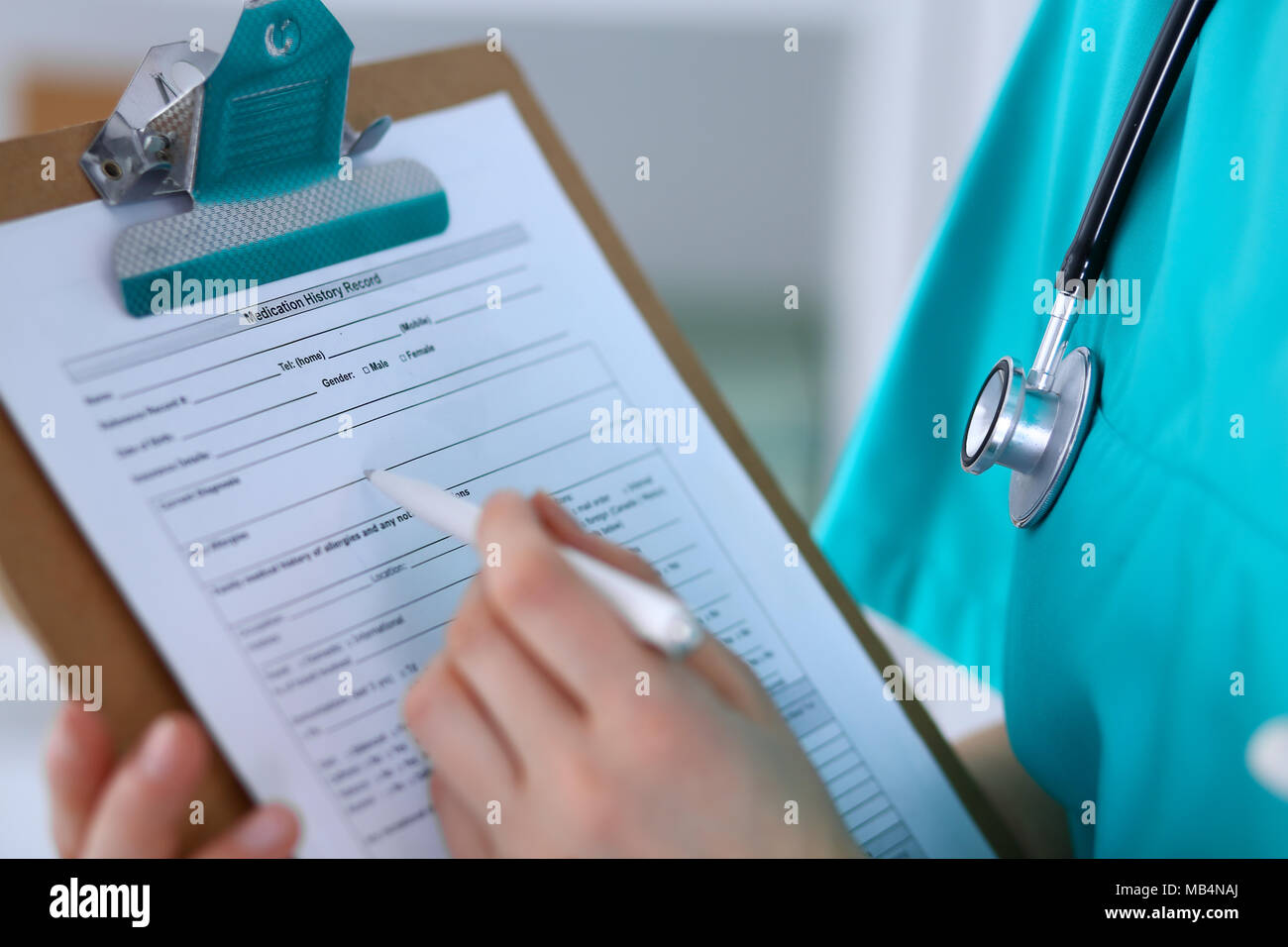 Female doctor filling up medical form on clipboard closeup. Physician ...