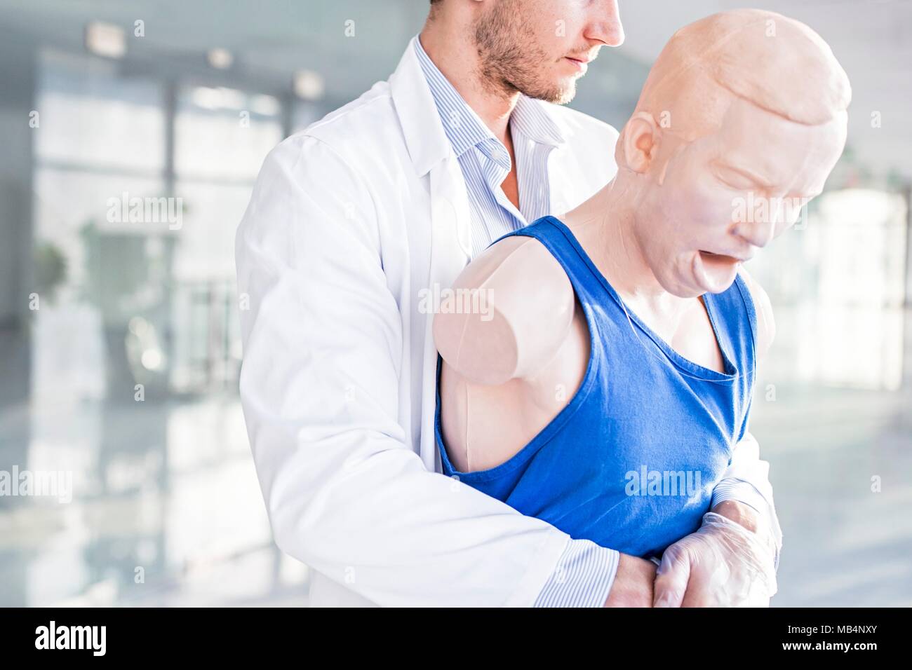 Doctor practising the Heimlich manoeuvre on a training dummy. Stock Photo