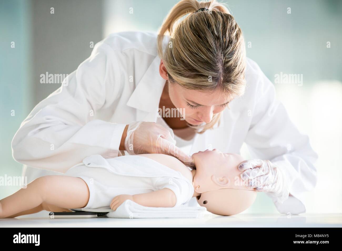 Doctor practising infant CPR on training dummies. Stock Photo