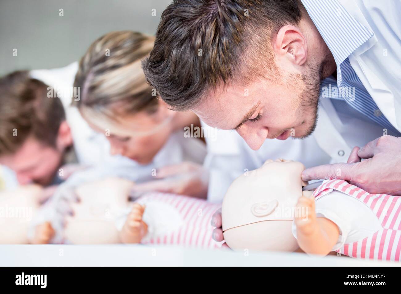 MODEL RELEASED. Doctor practising infant CPR on training dummies. Stock Photo