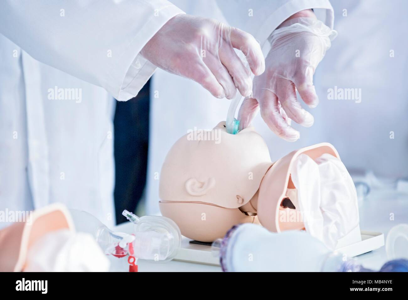 Doctors practising tracheal intubation on an infant training dummy. Stock Photo