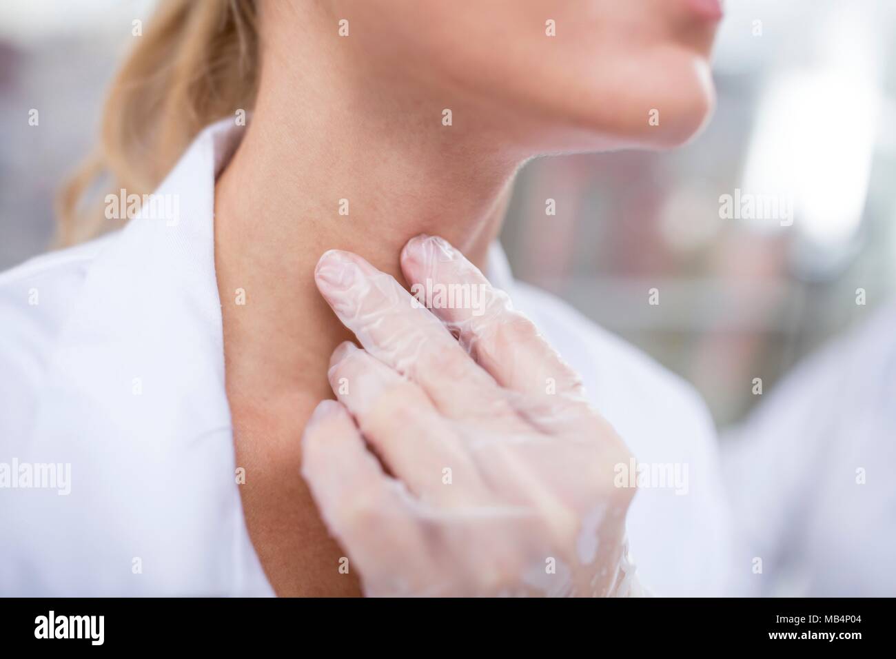 Doctor feeling her larynx. Stock Photo