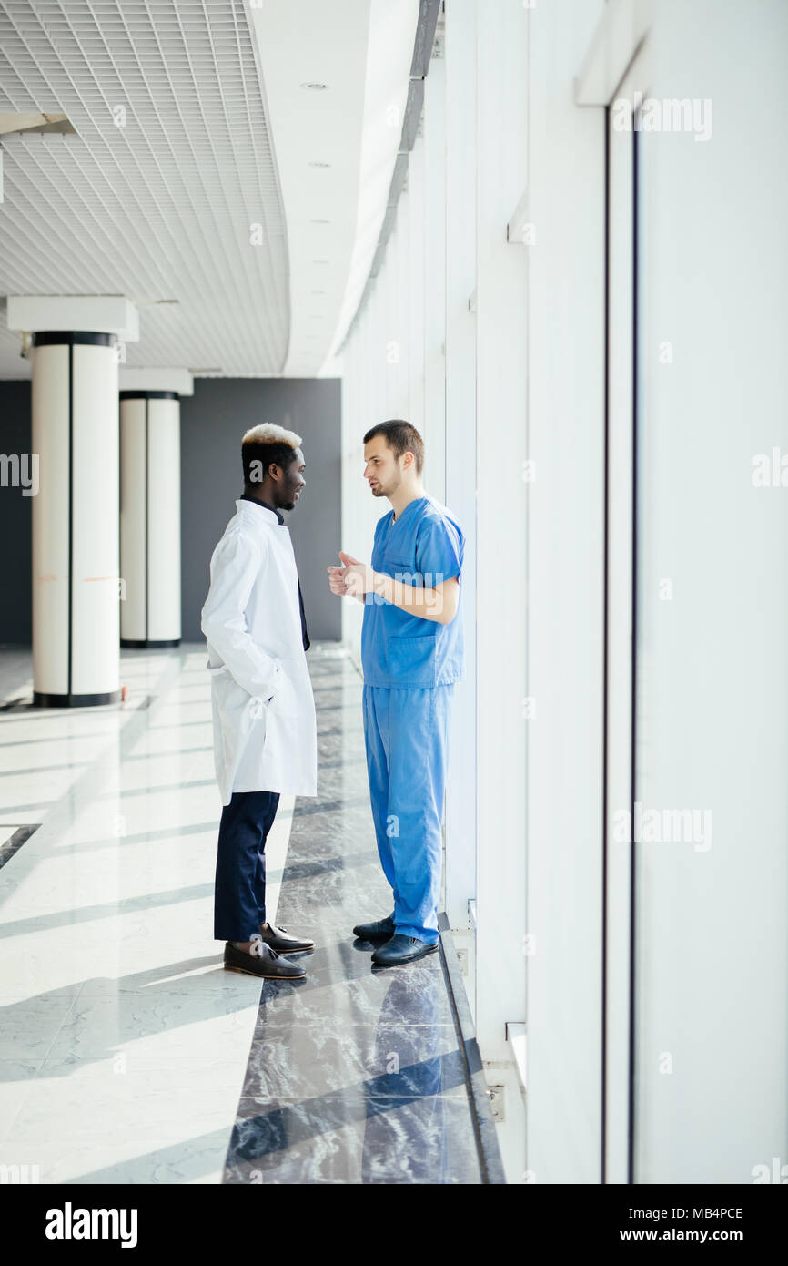 Medical Staff Having Discussion In Modern Hospital Corridor Stock Photo ...