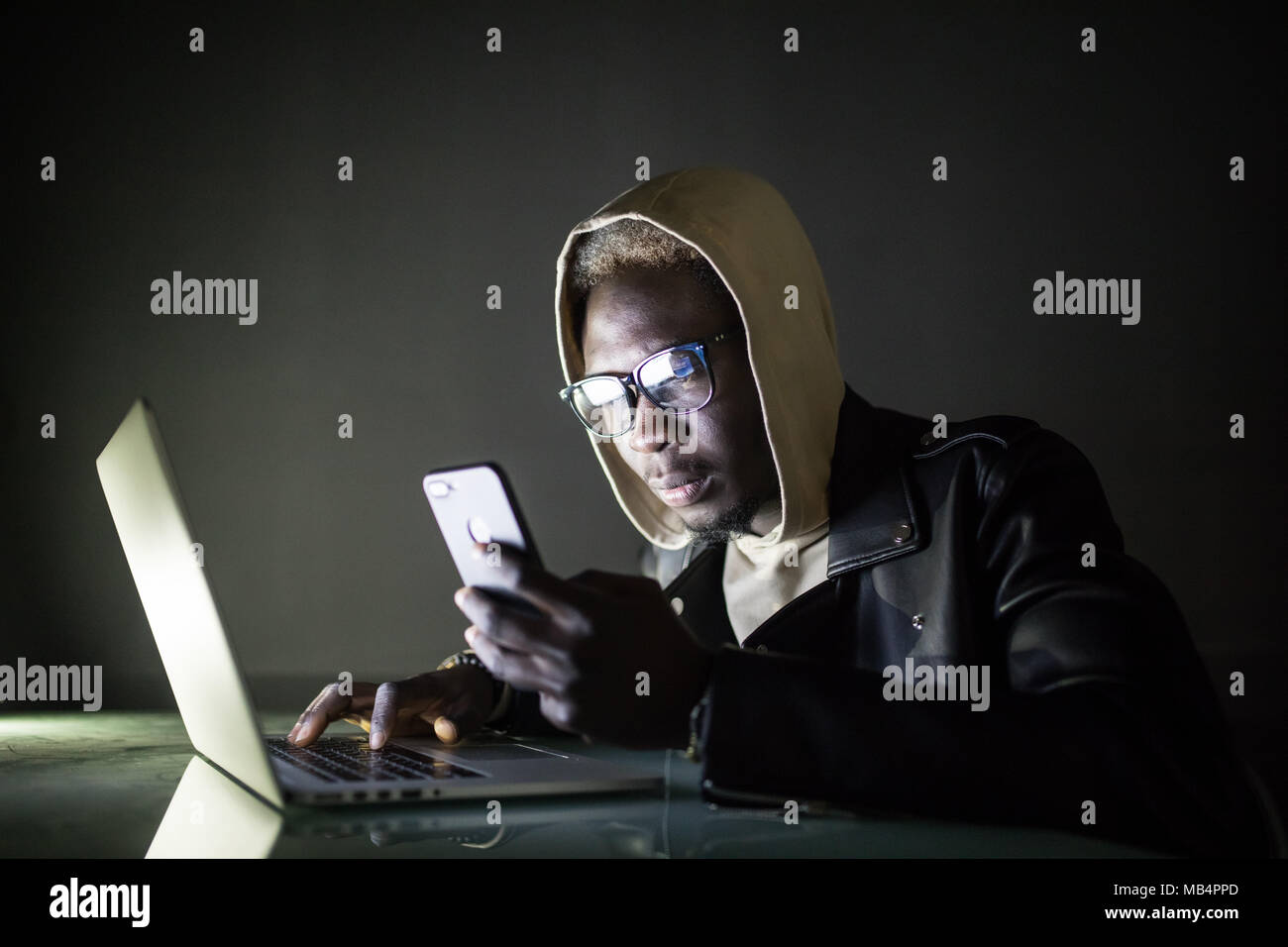 The developer is developing the software on his laptop in the night. the hacker is developing the malware, spyware, virus etc. Stock Photo