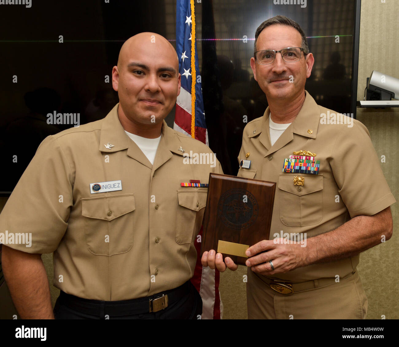 SAN DIEGO (Feb. 16, 2018) CAPT. Joel Roos, Naval Medical Center San Diego Commanding Officer,  presents Hospital Corpsman 3rd Class Class Armando Iniguez with the Junior Sailor of the Quarter award. Hospital Corpsman 3rd Class Iniguez received the award for his exceptional work and devotion to duty. Stock Photo