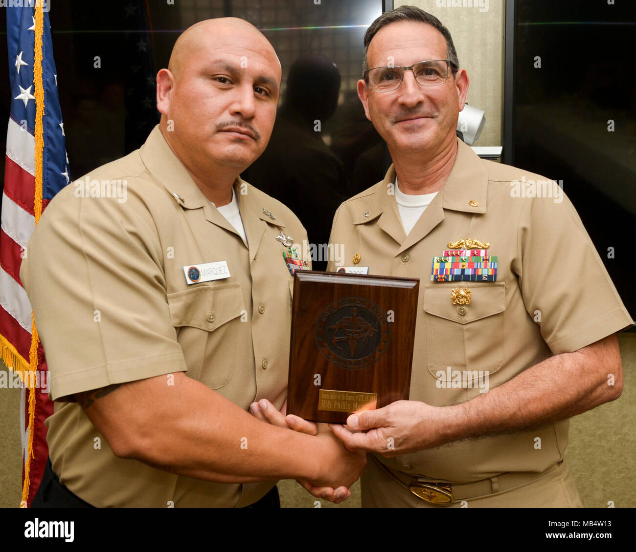SAN DIEGO (Feb. 16, 2018) CAPT. Joel Roos, Naval Medical Center San Diego Commanding Officer,  presents Hospital Corpsman 1st Class Phillip Marquez with the Senior Sailor of the Quarter award. Hospital Corpsman 1st Class Marquez received the award for his exceptional work and devotion to duty. Stock Photo