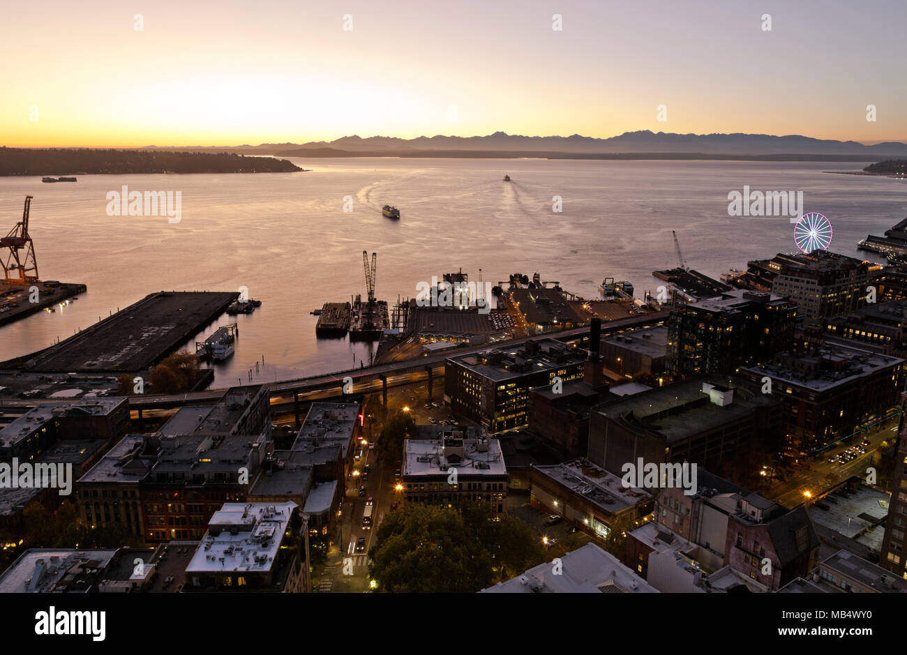 WASHINGTON - Ferries on Elliott Bay and Colman Dock after sunset over the Olympic Mtns from the Observation Deck on Seattle's Smith Tower. 2017 Stock Photo
