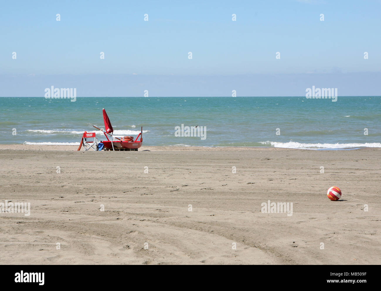 Soccer ball and red rescue items on the beach Stock Photo