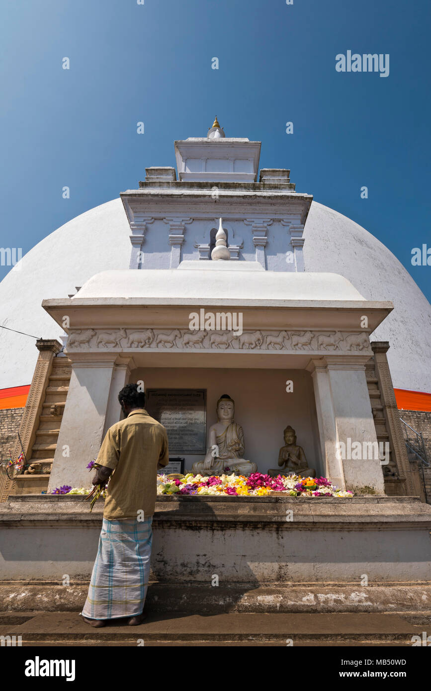 Vertical view of a man putting flowers at Ruwanwelisaya Dagoba or Stupa in Anuradhapura, Sri Lanka. Stock Photo