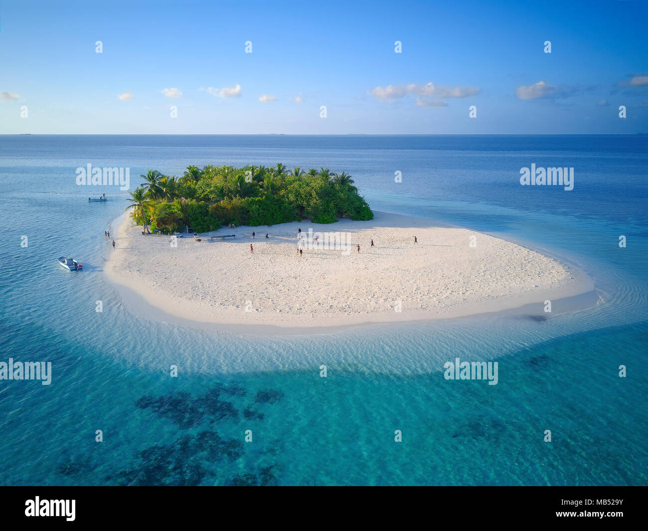 Uninhabited island for day trips with palm trees, bushes, sandy beach all around, offshore coral reef, Ari atoll, Indian Ocean Stock Photo
