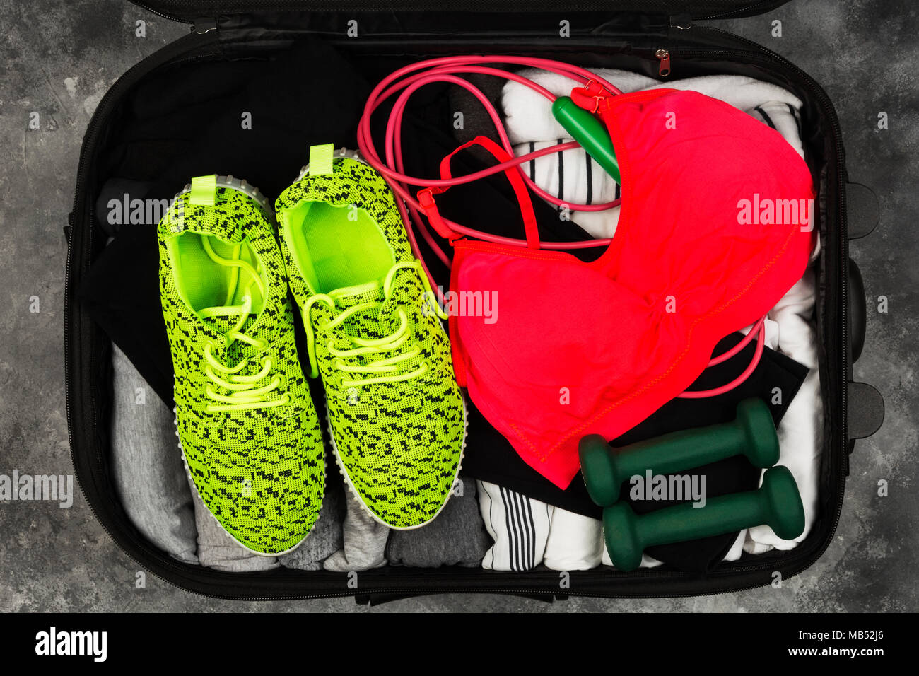 Sports accessories and sportswear in black suitcase. Concept sport during holiday. Top view Stock Photo