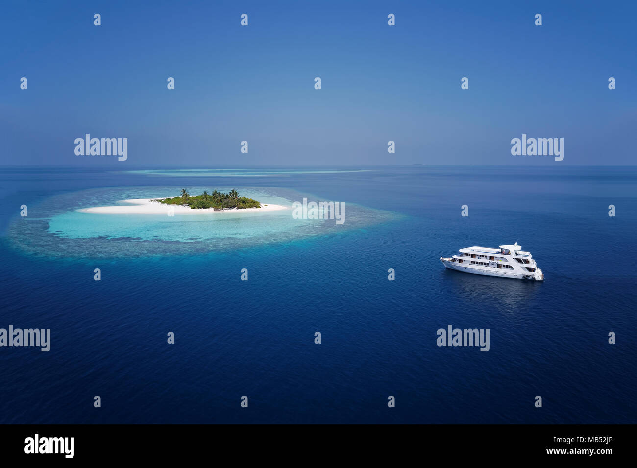 Diving safari ship MS Keana anchors off uninhabited palm island, Ari Atoll, Indian Ocean, Maldives Stock Photo