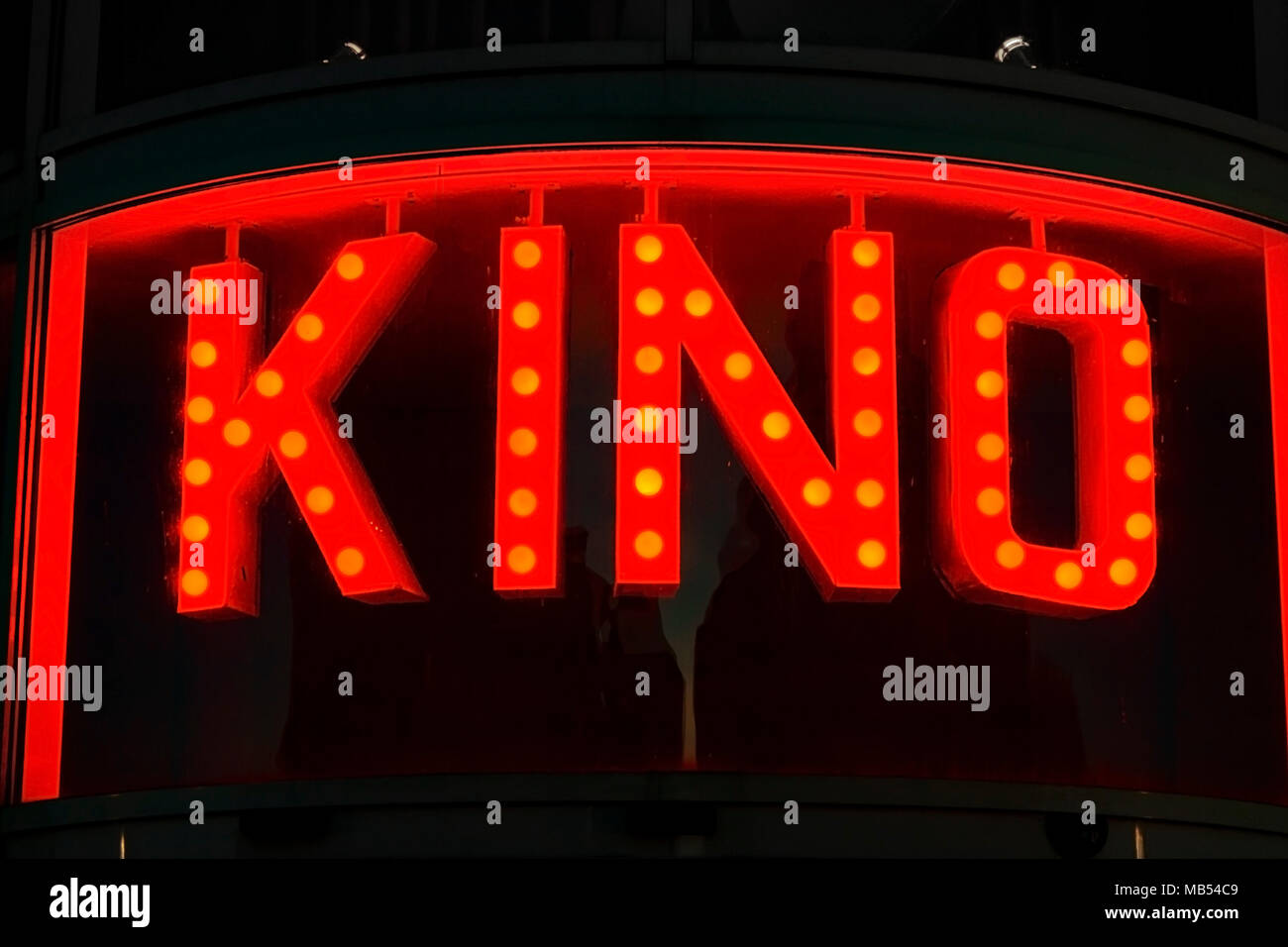 Illuminated 'KINO' (cinema) sign lit (lighted) up behind a curved window. Stock Photo