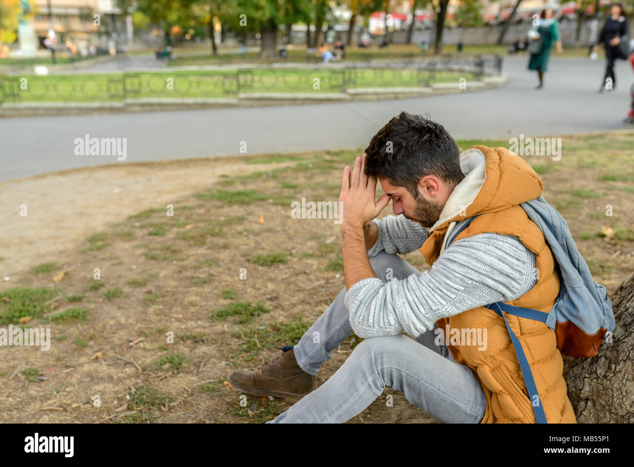 Displeased youngster is praying to the God in the city park Stock Photo