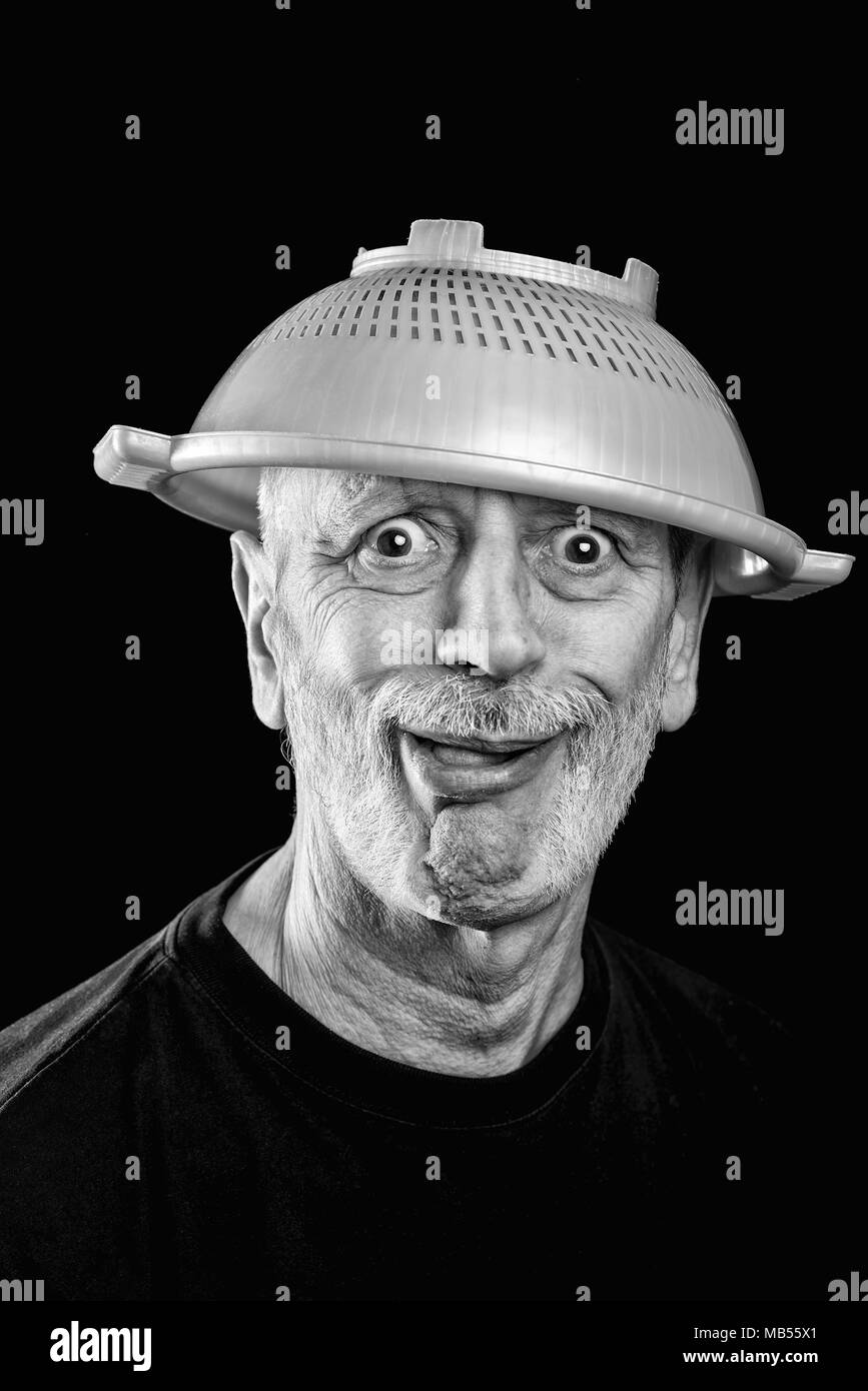 Dramatic black and white Portrait of a mad man with a plastic strainer on the head Stock Photo