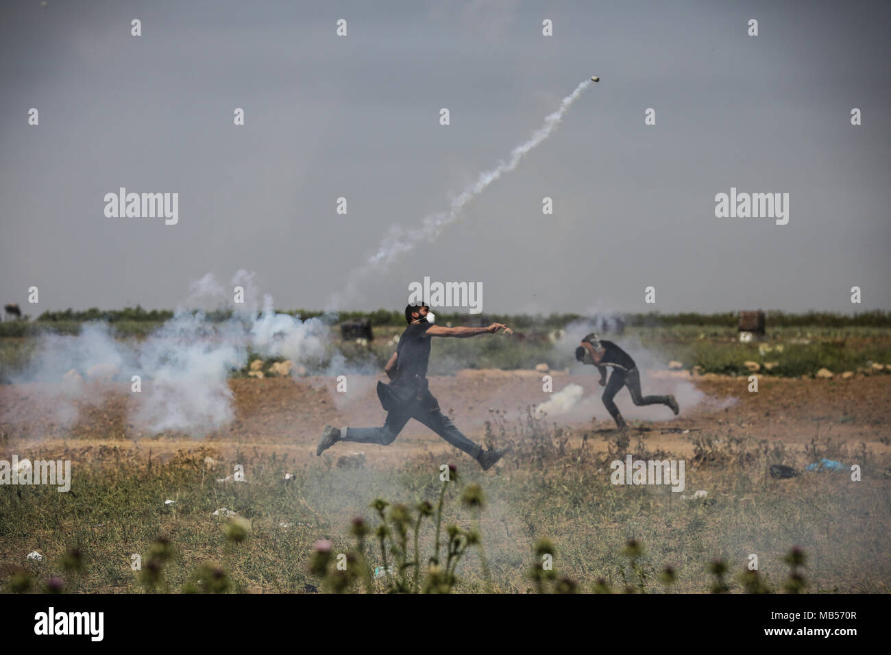 Gaza. 06th Apr, 2018. A Palestinian protester uses slingshot against Israeli security forces as they burn tires during a demonstration demanding the right of return and removal of the blockade following the 'Great March of Return'. Credit: Nidal Alwaheidi/Pacific Press/Alamy Live News Stock Photo