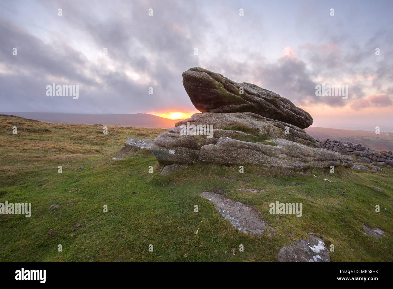 Sunset at the logan stone on Belstone Tor Dartmoor National Park Devon Uk Stock Photo