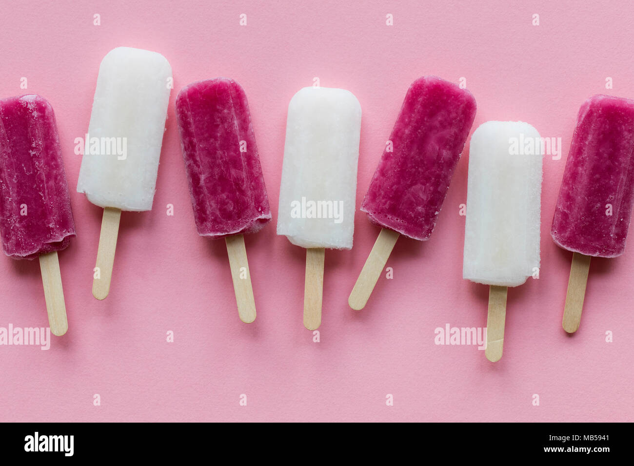 pink and white summer ice lollies on a pink background Stock Photo Alamy