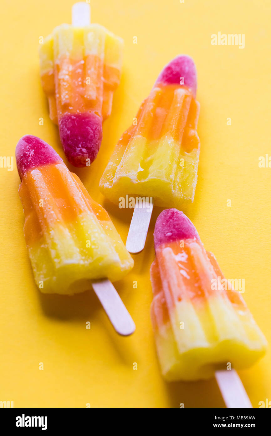 Rocket shaped summer ice lolly on a bright yellow background Stock Photo