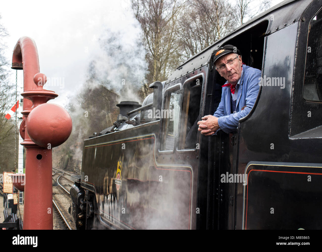 Steam Engine Train Driver with head through window at Train at Goathland Railway station, North Yorkshire, England Stock Photo