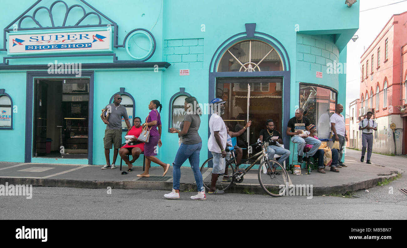 Locals hang out by a shoe store in Bridgetown, Barbados. Stock Photo