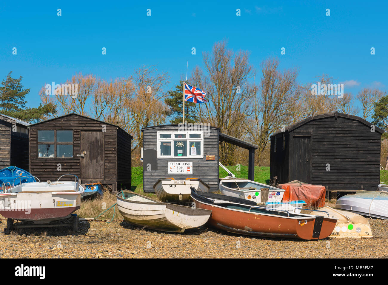 England beach UK, view of boats and fishermens' huts on the beach at Orford, Suffolk, East Anglia, England, UK. Stock Photo