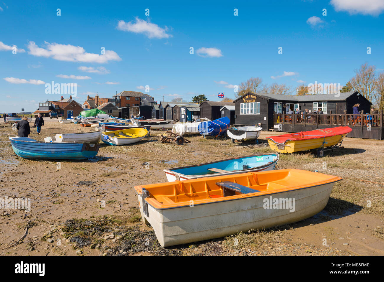 Suffolk coast UK, view of colourful boats and a tea shop on the beach at Orford quay, Suffolk, East Anglia, England, UK. Stock Photo