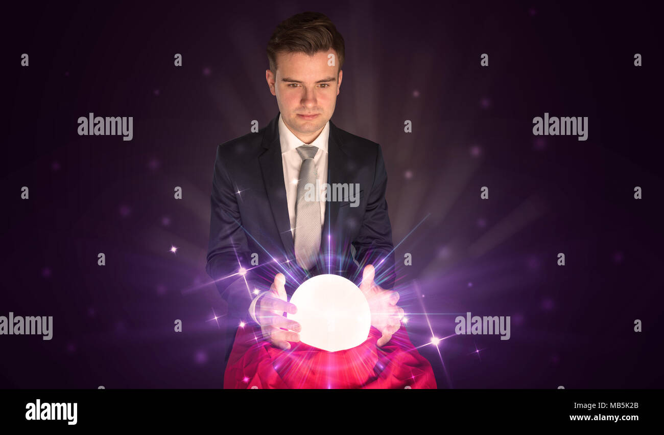 Young businessman sitting with crystal ball in action Stock Photo - Alamy