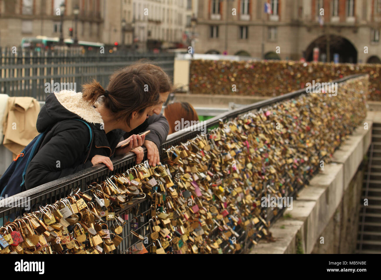 Paris, France -  03 April 2018. People admire a bridge covered in padlocks on the bridge at Pont Neuf on 03 April 2018.  The first Iron bridge built in France, had its railings replaced with glass panels after they collapsed under the weight on the metal padlocks and this culture has cropped up in other bridges in Paris. General view of Paris, France. @ David Mbiyu/Alamy Live News Stock Photo