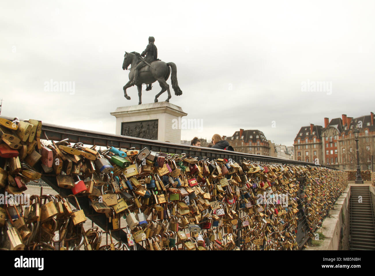 Paris, France -  03 April 2018. People admire a bridge covered in padlocks on the bridge at Pont Neuf on 03 April 2018.  The first Iron bridge built in France, had its railings replaced with glass panels after they collapsed under the weight on the metal padlocks and this culture has cropped up in other bridges in Paris. General view of Paris, France. @ David Mbiyu/Alamy Live News Stock Photo