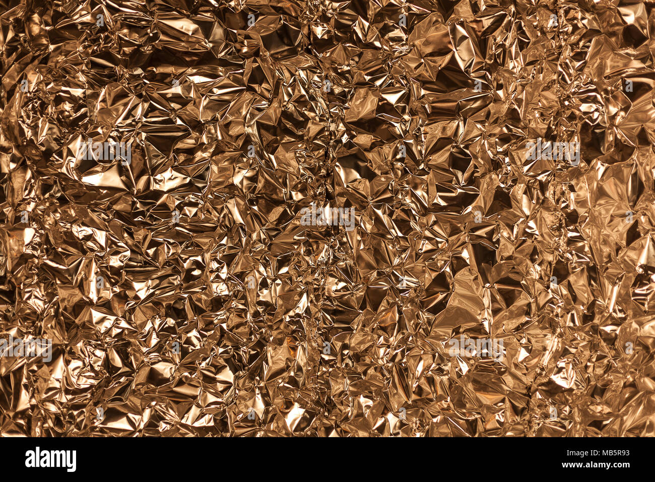 Crumpled Aluminum Foil Background Texture - in Gold Color Stock