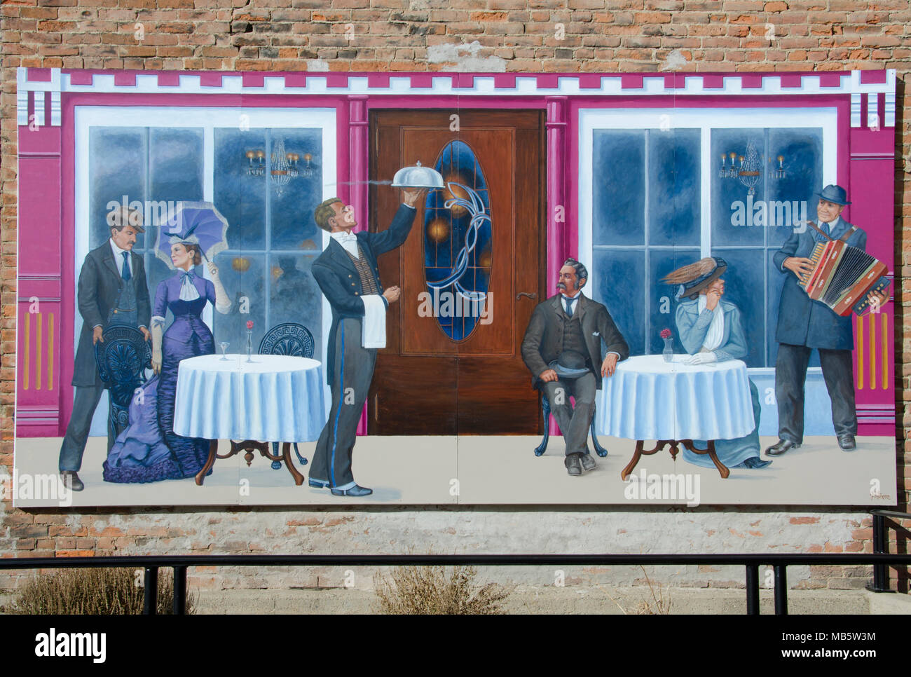 A painting reflecting dining in another era is posted on the side of a Victorian building in Leadville, Colorado. Stock Photo