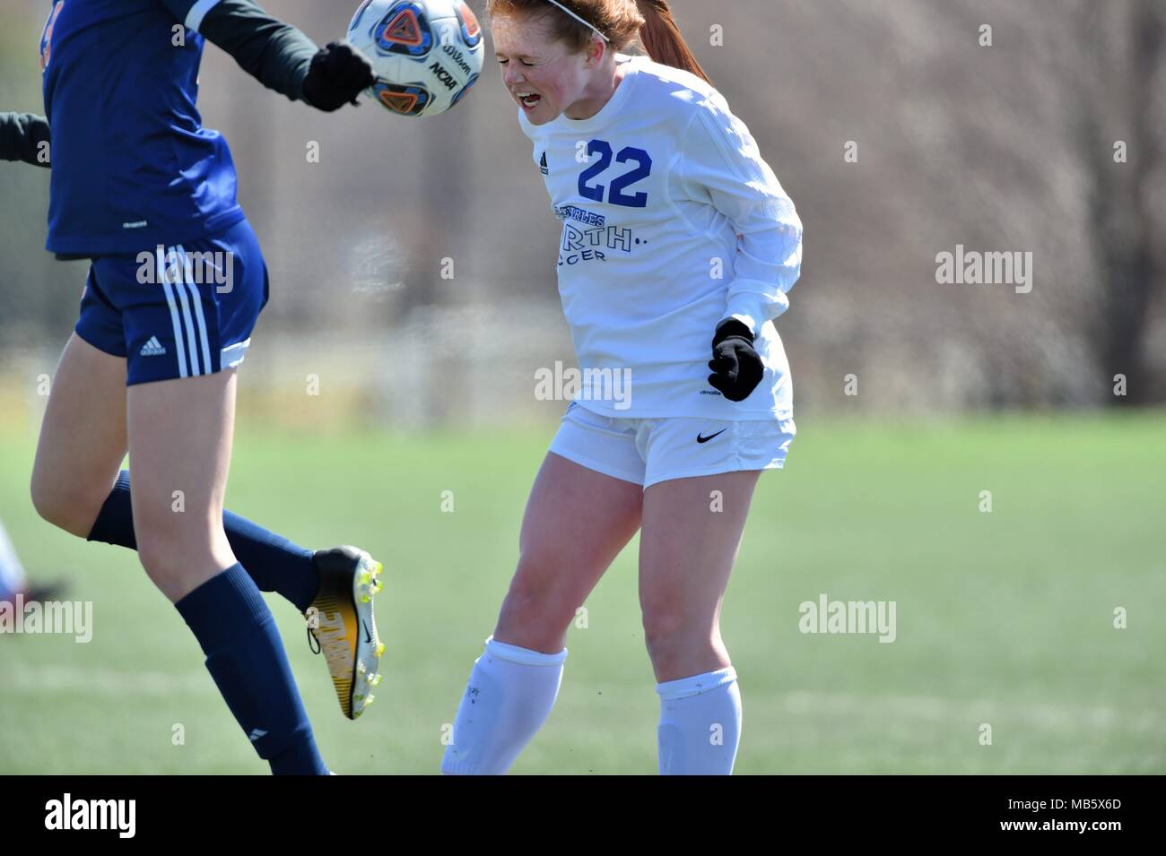 High school player executing a header in traffic. USA. Stock Photo