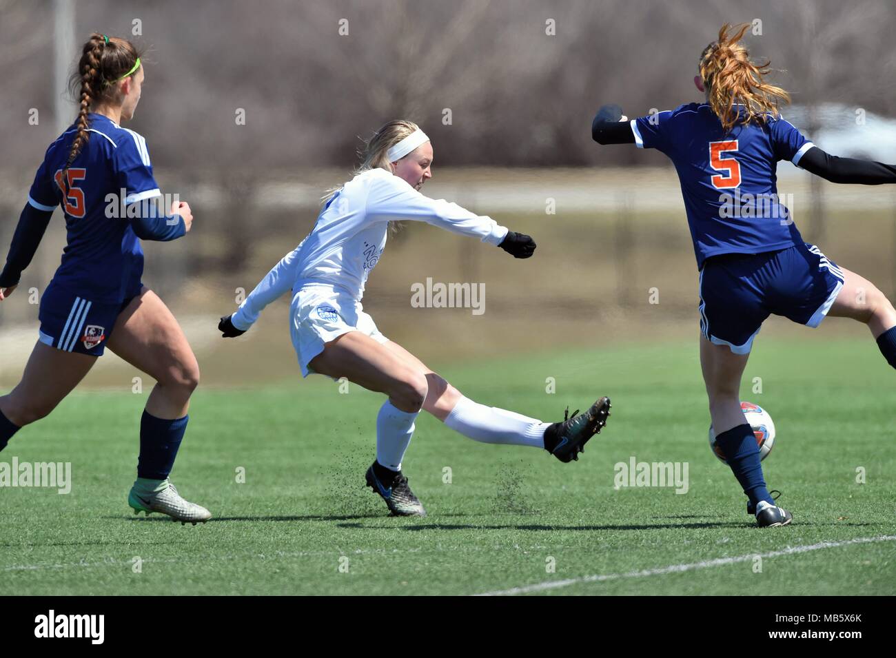 While between a pair of defenders, an opposing  midfielder firing off a shot that found the back of the net for a goal. USA. Stock Photo