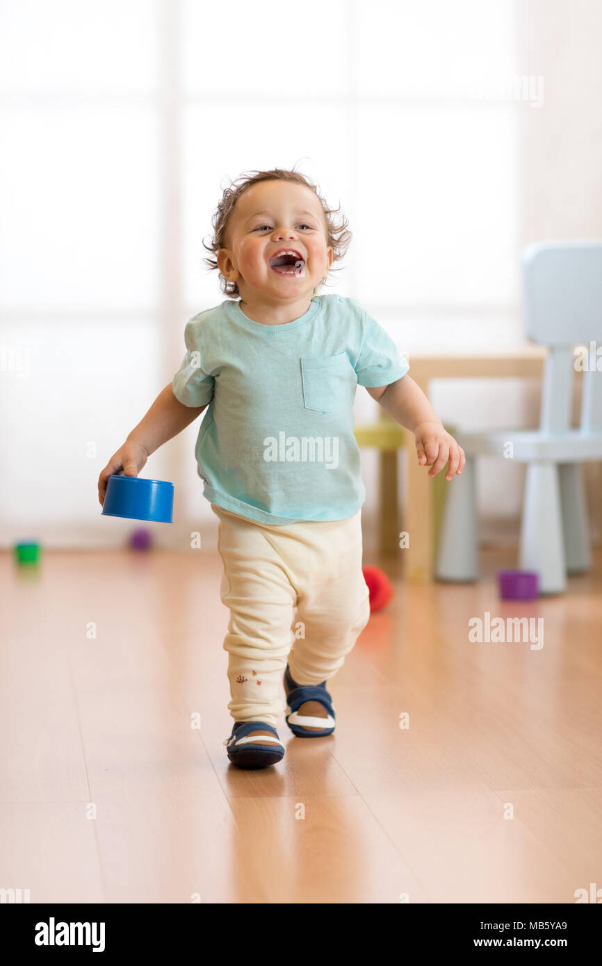 First steps of baby boy toddler learning to walk in living room