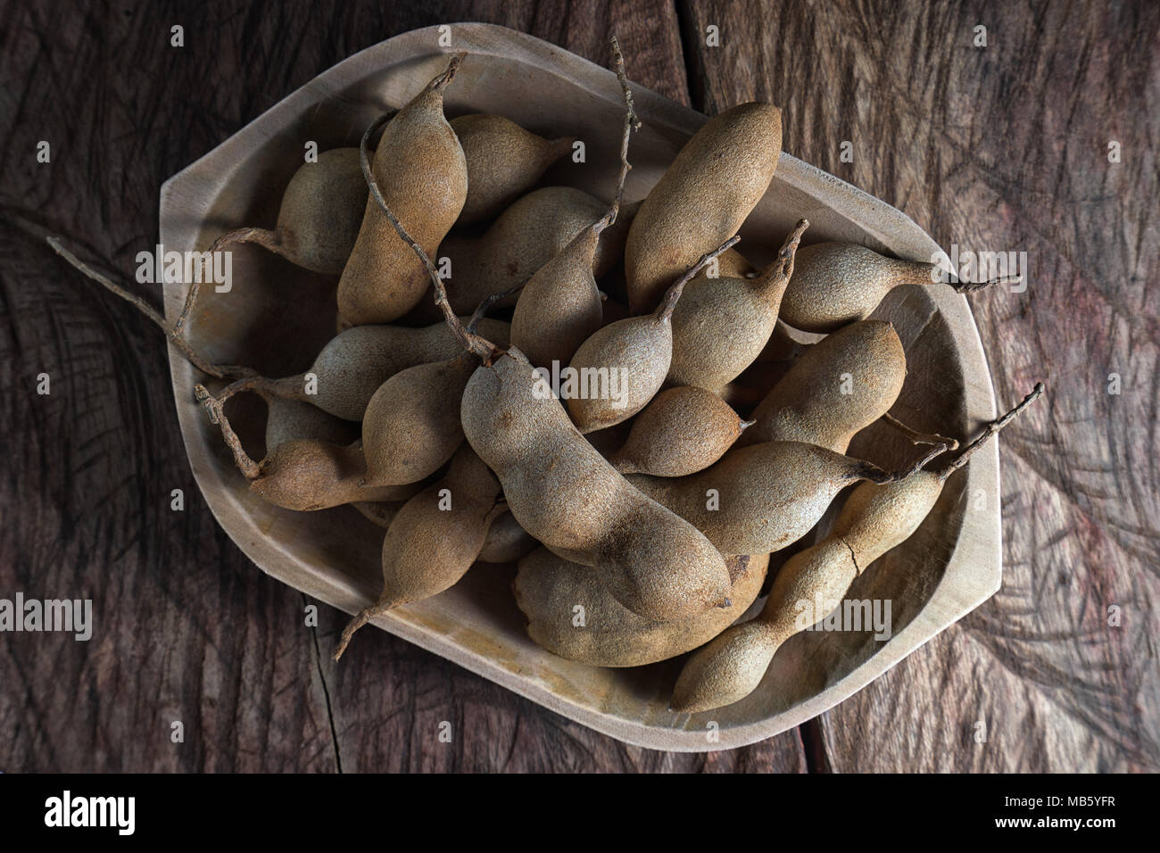 whole tamarind fruits in wooden bowl Stock Photo Alamy