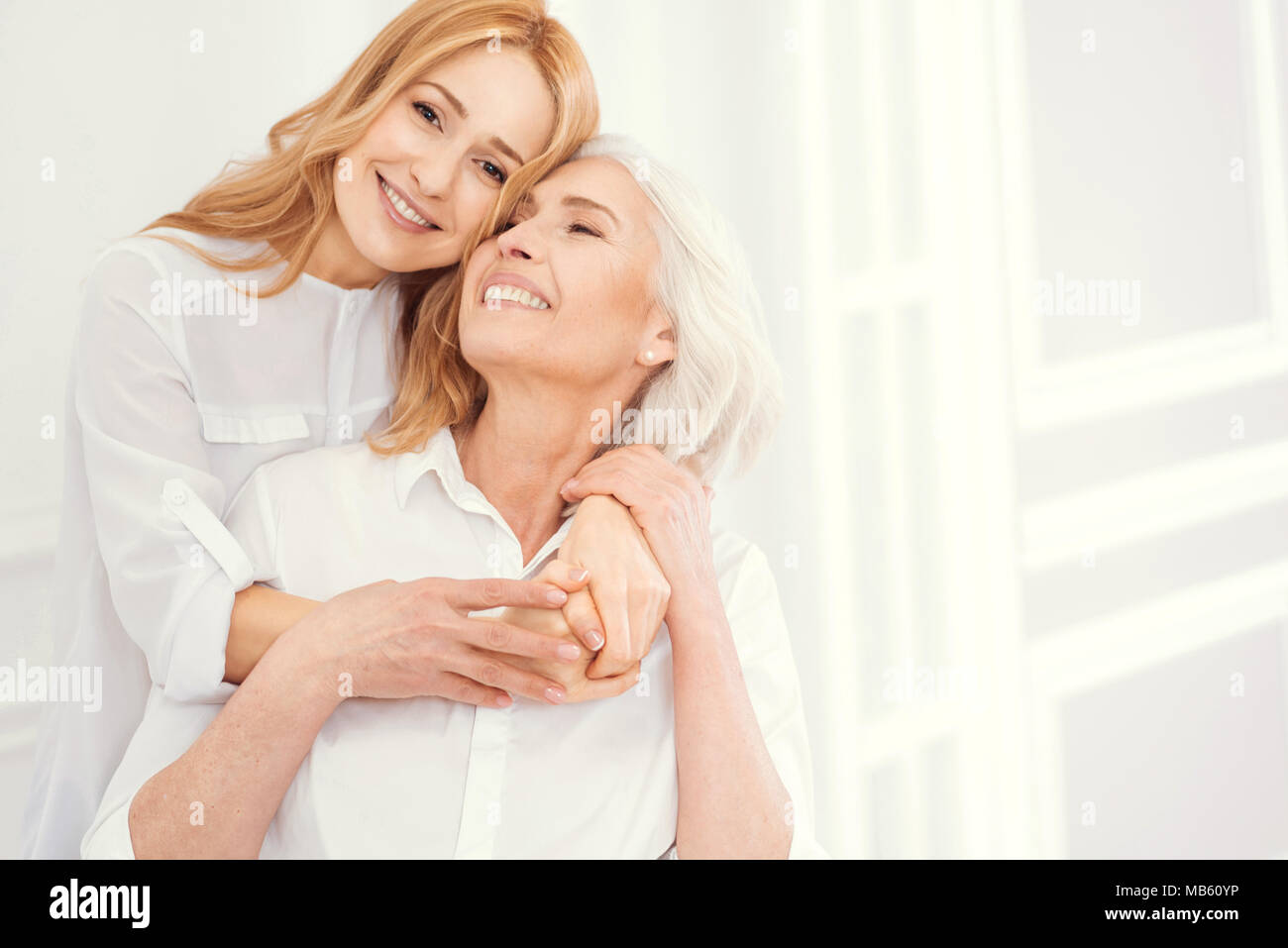 Tender mature woman embracing her senior mom with love Stock Photo