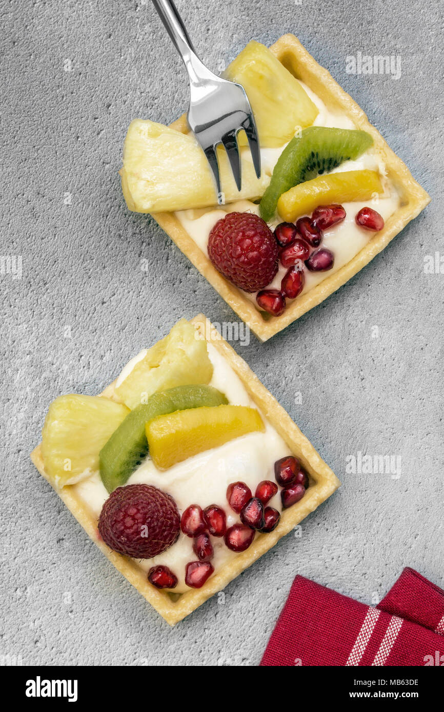 Exotic Fruit Tarts on a rustic background with a fork Stock Photo