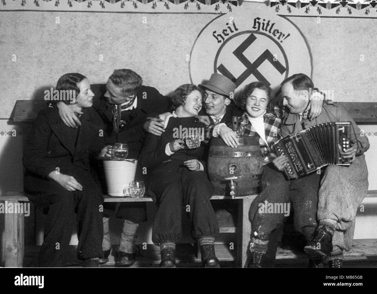 Group of young Germans drinking beer under a Heil Hitler Swastika  in Vogelsberg Germany 1933 Deutschland 1930s Stock Photo