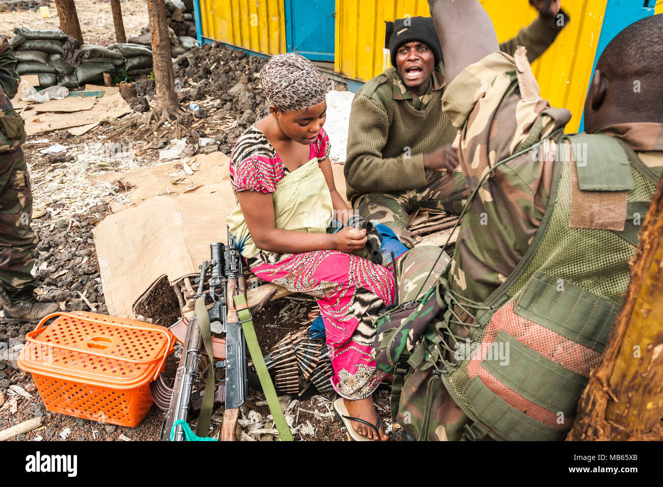 A wife on the frontline during hostilities between the DRC and the Rwandan backed M23 militia. Wives and girlfriends help soldiers with cooking Stock Photo