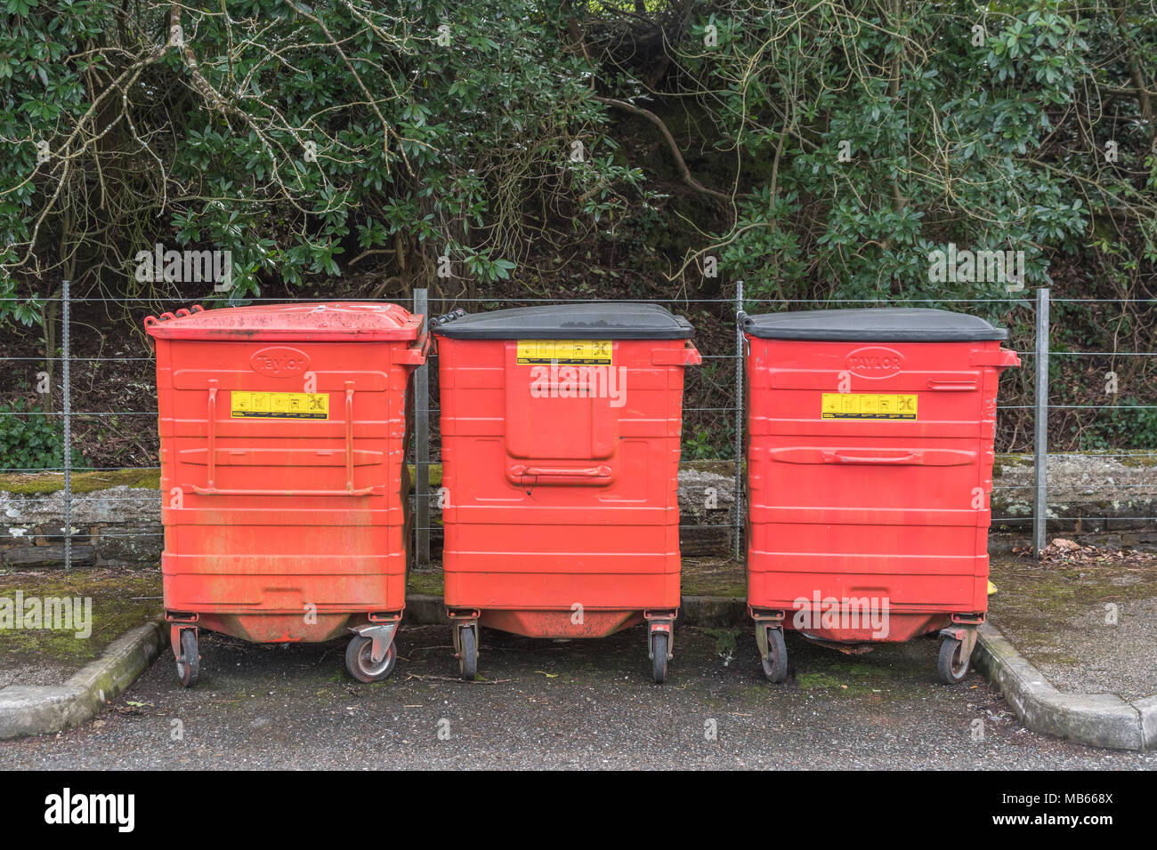 Three large size red wheelie bins / wheely bins / rubbish bins