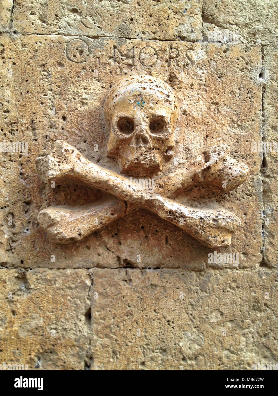 Skull and crossed bones sculpture in a wall stone with the inscription MORS  in Spain Stock Photo - Alamy
