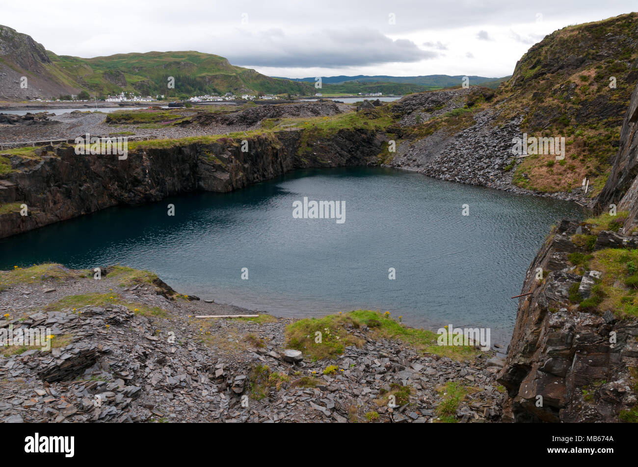 Slate Mining on Easedale, Slate Isles, Scotland with village of Ellenabiech on Seil in background Stock Photo