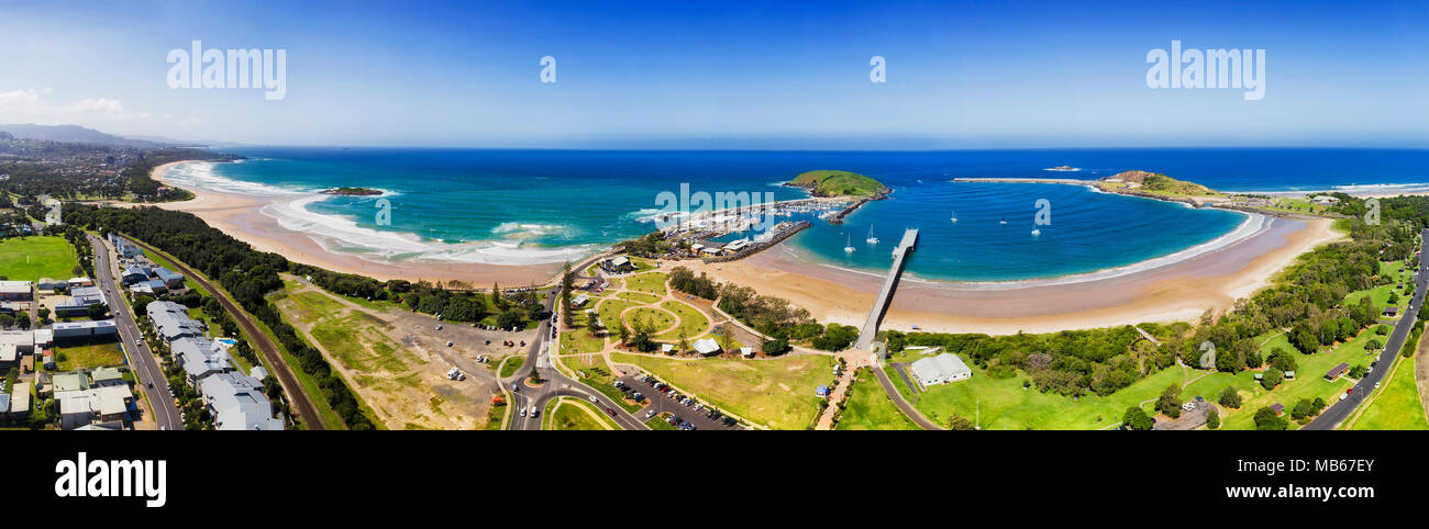 Coffs harbour regional town on NSW North coast in elevated aerial view - wide panorama of town's beach, marina, harbour and muttonbird island. Stock Photo