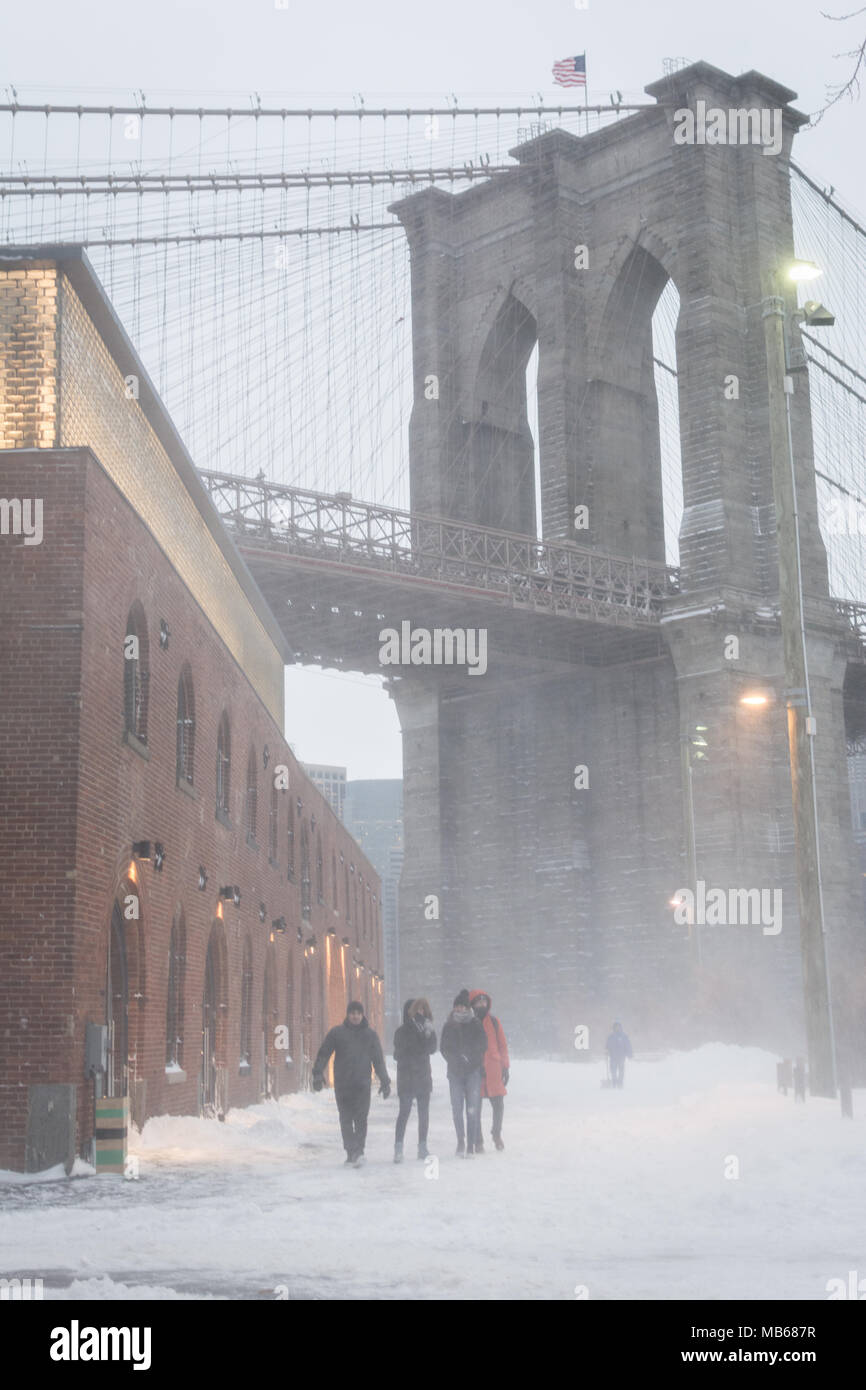 BROOKLYN, N.Y. - January 4, 2018 - Tourists walk down a snow-covered Brooklyn Bridge Park in DUMBO after a 'bomb cyclone' blizzard hit the Northeast United States. Stock Photo