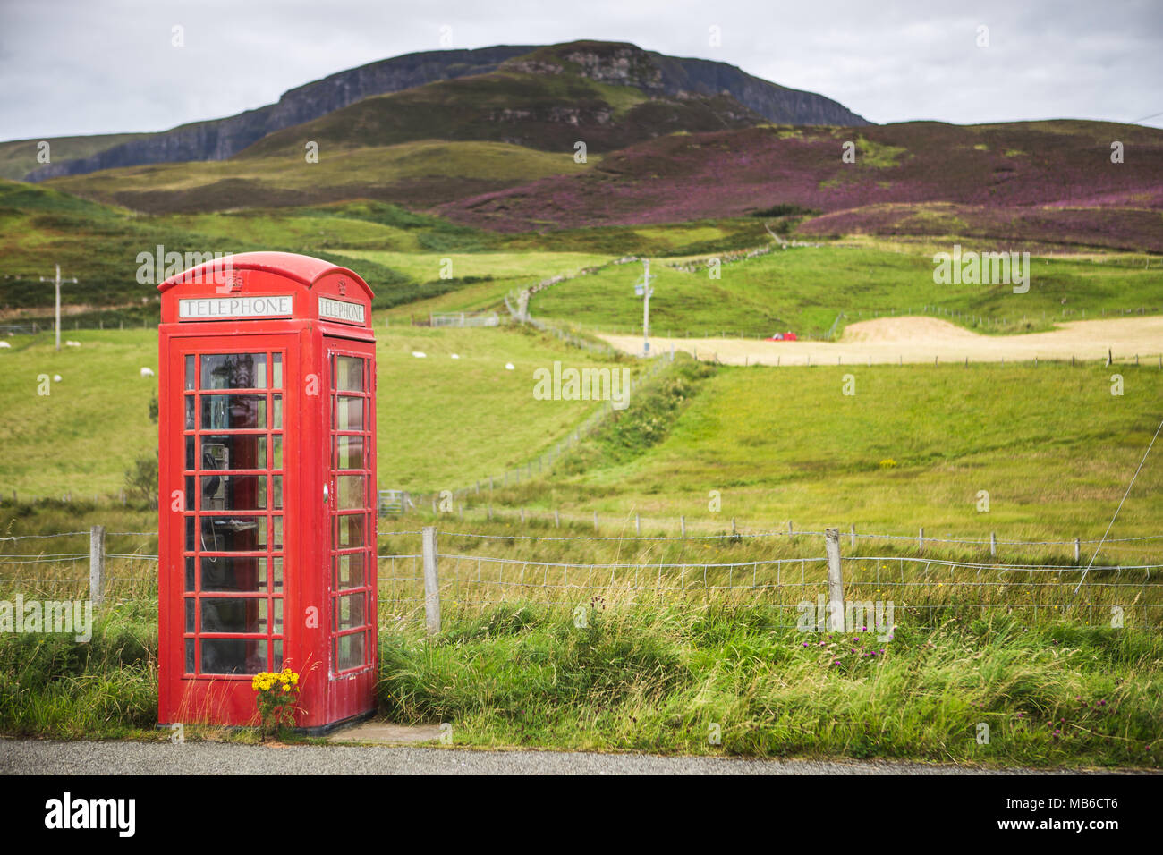 Traditional red phone box next to a single track road of Isle of Skye, Scotland Stock Photo
